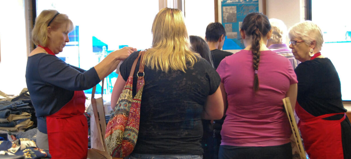 Salmon Creek: Assistance League of Southwest Washington members in red aprons, Ann McEnemy-Ogle, left, and Nancy Gaston, help foster teens find clothing at the leagueis annual back-to-school clothing event.