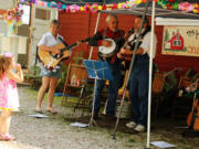 Venersborg: A little girl blows bubbles as Martin Brothers and Friends play bluegrass for the Historic Venersborg Schoolis 100th birthday celebration.