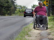 Jesse Magana struggles along the overgrown sidewalk on beside Northeast 112th Avenue in Vancouver.