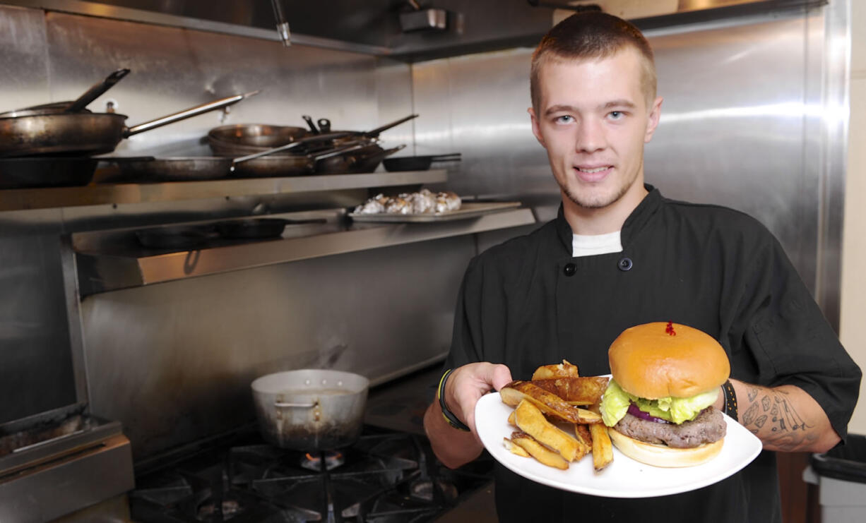 Austin Theroux displays a kangaroo burger in the kitchen at Bone's restaurant in Battle Ground.