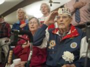 Pearl Harbor survivor Paul Johnson salutes Monday morning during the Pledge of Allegiance at the observance commemorating the 74th anniversary of the attack on Pearl Harbor. Wife Margaret Johnson is next to him.