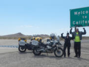 La Center: La Center Lions Club members Mark and Debbie Mansell rest on July 8 at the California state line near the end of a U.S. motorcycle tour that took them across 48 states in 24 days.