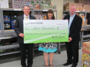 Meadow Homes: CenturyLink Vice President Christopher Denzin, left, and Marketing Manager Martin Flynn present big bucks to Share Executive Director Diane McWithey.