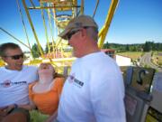 Melissa Macy, 18, of Portland, rides the Ferris wheel on Tuesday with firefighter Jeff Van Laeken, left, and retired firefighter Roy Alvstad.