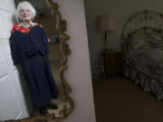 Maude Ryan, 98, holds the navy blue dress that she wore on her 25th wedding anniversary in 1961 at her Orchards home.