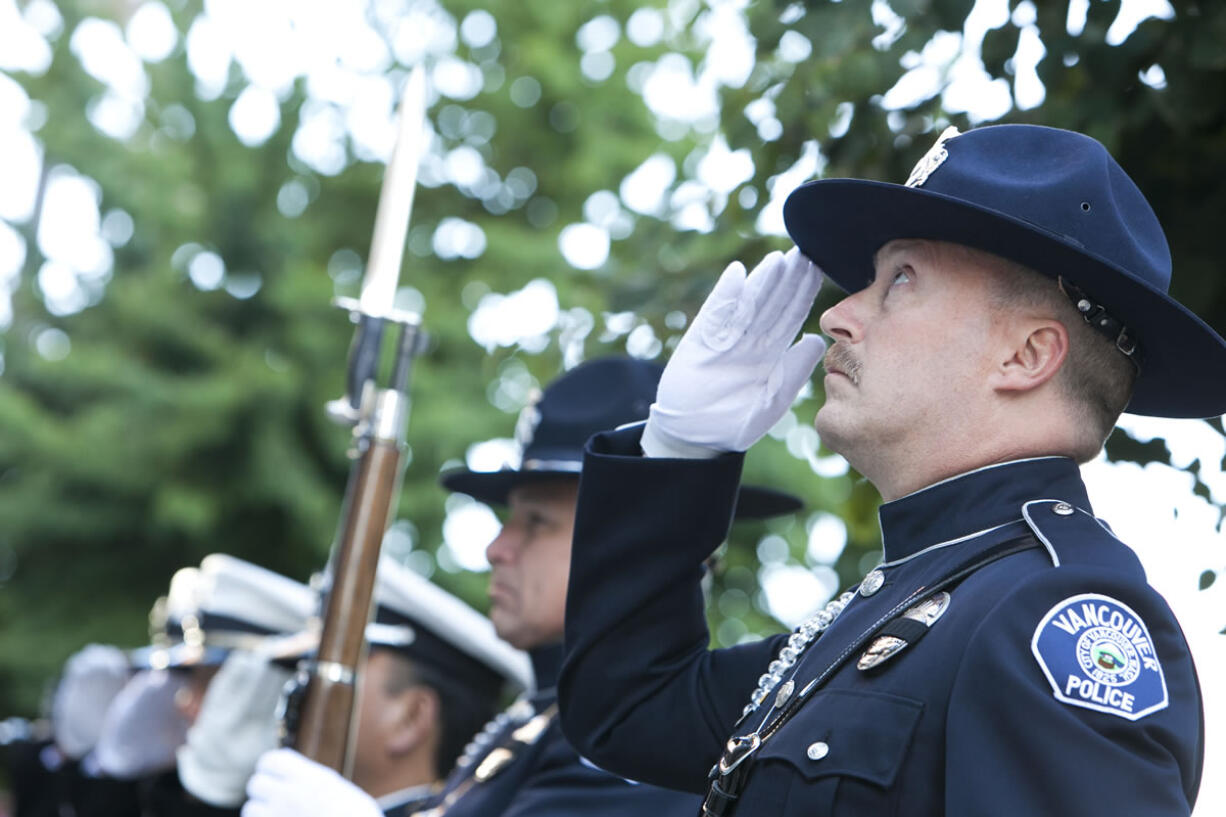 Honor Guards from the Vancouver Police and Fire Department watch as the flag is raised during the Patriot Day ceremony at City Hall on Tuesday.