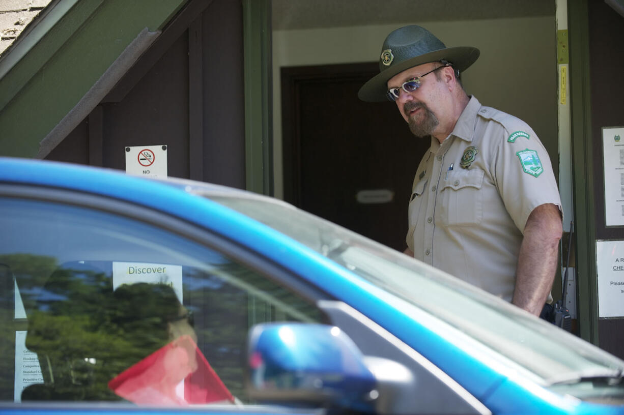 Battle Ground Lake State Park manager Jim Presser greets visitors Thursday.