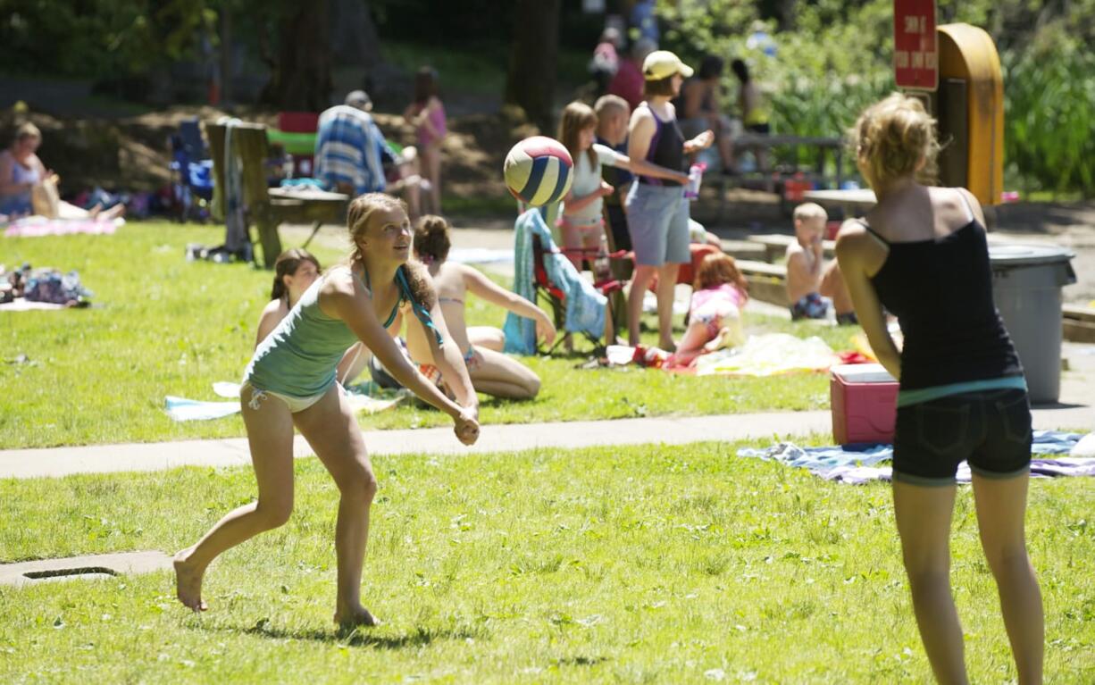 Minda Tikka, 13, from Yacolt, left, and Kalyn Uskoski, 12, from Battle Ground, play volleyball at Battle Ground Lake State Park on Thursday.