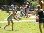 Minda Tikka, 13, from Yacolt, left, and Kalyn Uskoski, 12, from Battle Ground, play volleyball at Battle Ground Lake State Park on Thursday.