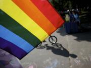 A bicyclist rides past a rainbow flag during the 18th annual Saturday in the Park event celebrating the area's LBGT community.