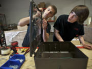 Kyle Hunt, 20, left, and Anthony Hipp, 21, assemble one of Global TTL's energy-efficient LED commercial and industrial light fixtures.