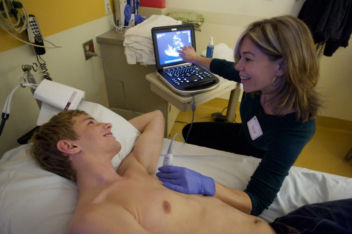 ECHO Tech Deborah Reyes performs an echocardiogram on Noah Morasch, 17, a junior at Mountain View High School, on Saturday.