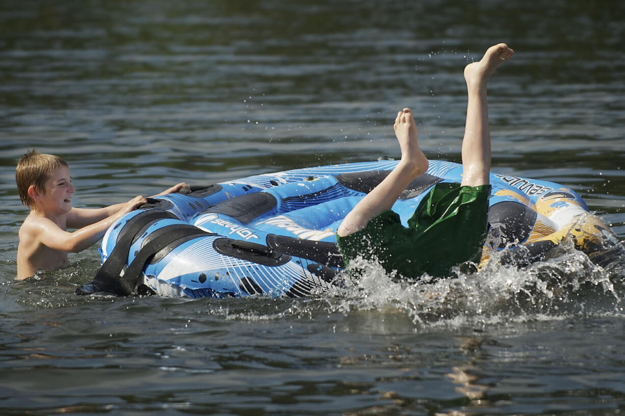 Vancouver residents Tyler Bacon, 10, left, and his brother Matthew Bacon, 13, cool off at Klineline Park on a hot day earlier this year.