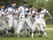 The Skyview baseball team swarms Reiley Henderson (3) after Henderson drove in the winning run in the bottom of the seventh inning as the Storm rallied to beat Heritage 6-4 and win the 4A district championship game Thursday at Propstra Stadium.