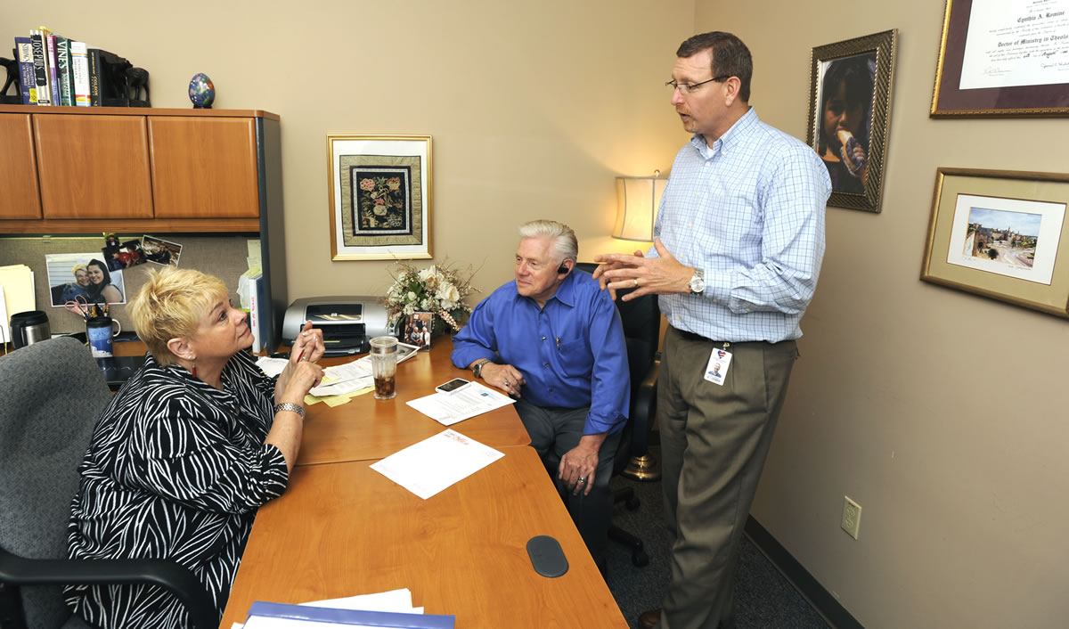 Cyndi Romine, left, talks with Steve Johnson, the organization's marketing director, and husband, Greg Romine, in her office at Called to Rescue in east Vancouver on Thursday afternoon.