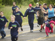 From left, holding hands, Lynnadele Schoeneberg, Fiona Wimber, Dennis Dole Jr. and Deanna Sanders finish the 11-mile Law Enforcement Torch Run on Wednesday.