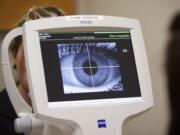 Clinical Specialist Michelle Simmons has her cornea scanned by Ophthamalic Technician Karli Maughan in preparation for today's opening of The Vancouver Clinic's new eye-care clinic.