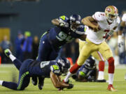 Seattle Seahawks K.J. Wright, left, and D'Anthony Smith give chase to San Francisco 49ers quarterback Colin Kaepernick in the second half Sunday.