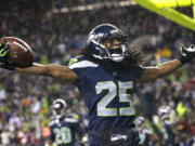 Seattle Seahawks' Richard Sherman motions to fans after an interception in the end zone against the San Francisco 49ers in the second half Sunday.