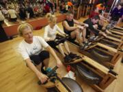 Diana Smith, left, works out on the rowing machine during the ShockWave class at Northwest Personal Training.