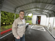 Don Espey, president of F.I.S.H. of Orchards, stands under a new carport that was installed to keep clients dry while they wait outside of the food bank.