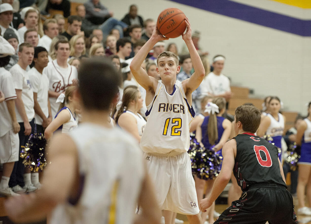 Columbia River&#039;s Jacob Hjort (12) passes to an open teammate past Camas defender Jake Hansel (0) in the second quarter Tuesday night, Dec. 1, 2015 at Columbia River High School gym.