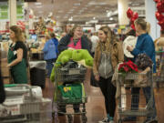 Jenna Plant of Vancouver, from center with alligator, chats with fellow shoppers Makenna Elliott, 16, and her mom, Rene, during Black Friday shopping Friday morning, Nov. 27, 2015 at the Southeast 164th Avenue Fred Meyer.