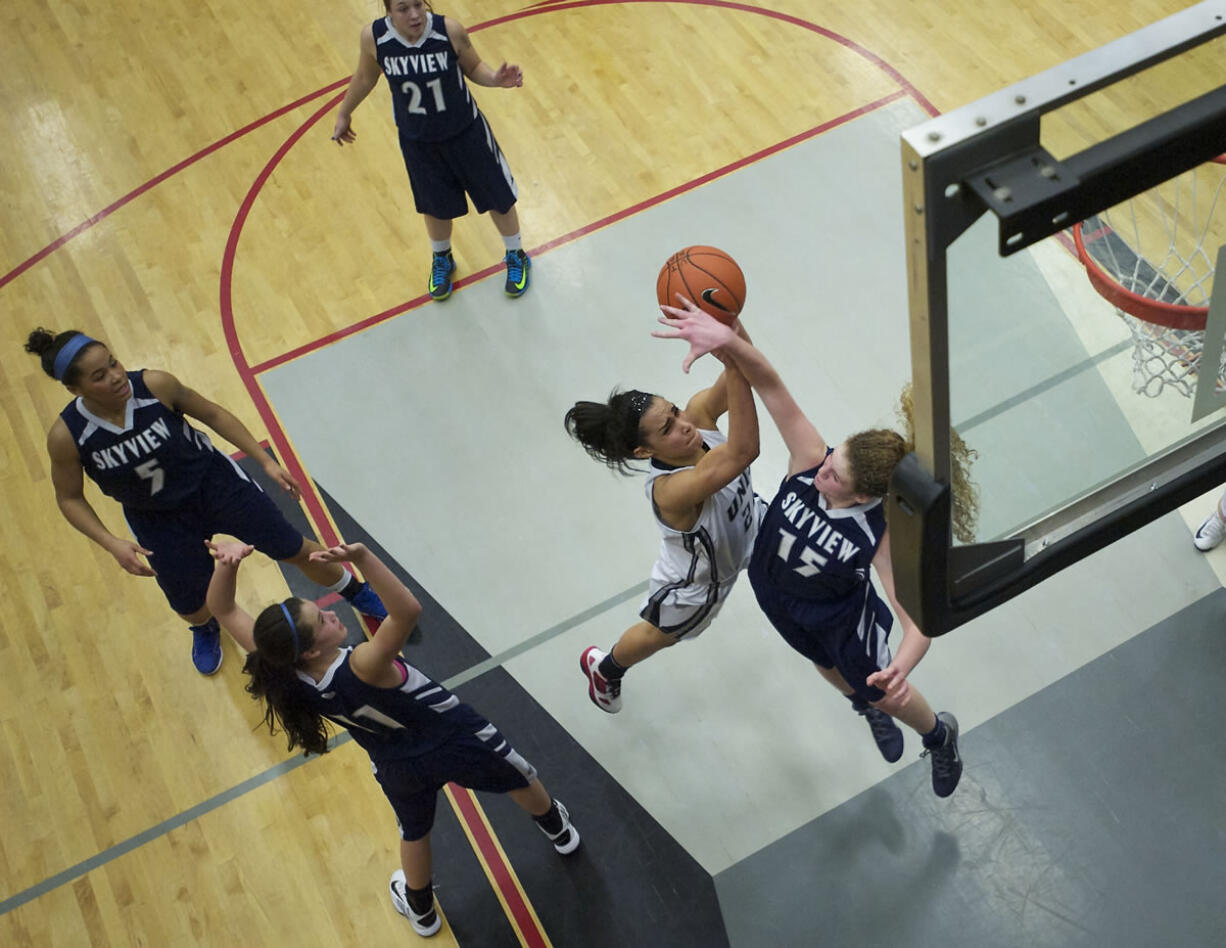 Skyview's Neesen Bristow contests Union's Jessica Chatman in the paint during Skyview's league-clinching win.