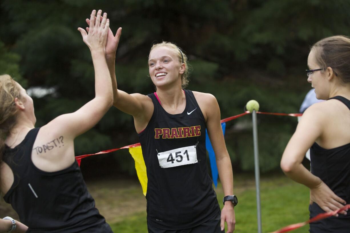 Prairie's Nicole Goecke celebrates with teammates after winning the 3A district cross country title at Lewisville Park on Thursday.