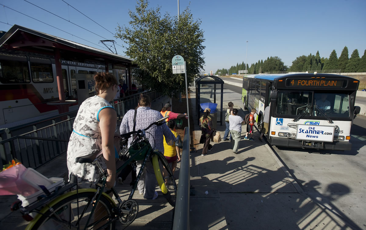 Commuters exit the MAX train at the Delta Park/Vanport Transit Center and head for a C-Tran bus Sept.