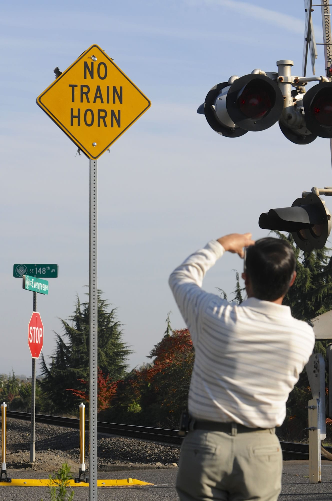 Roger Parsons, spokesman for the East Vancouver Train Horn Noise Advisory Committee, photographs a sign next to the upgraded crossing at Southeast 147th Avenue on Wednesday.