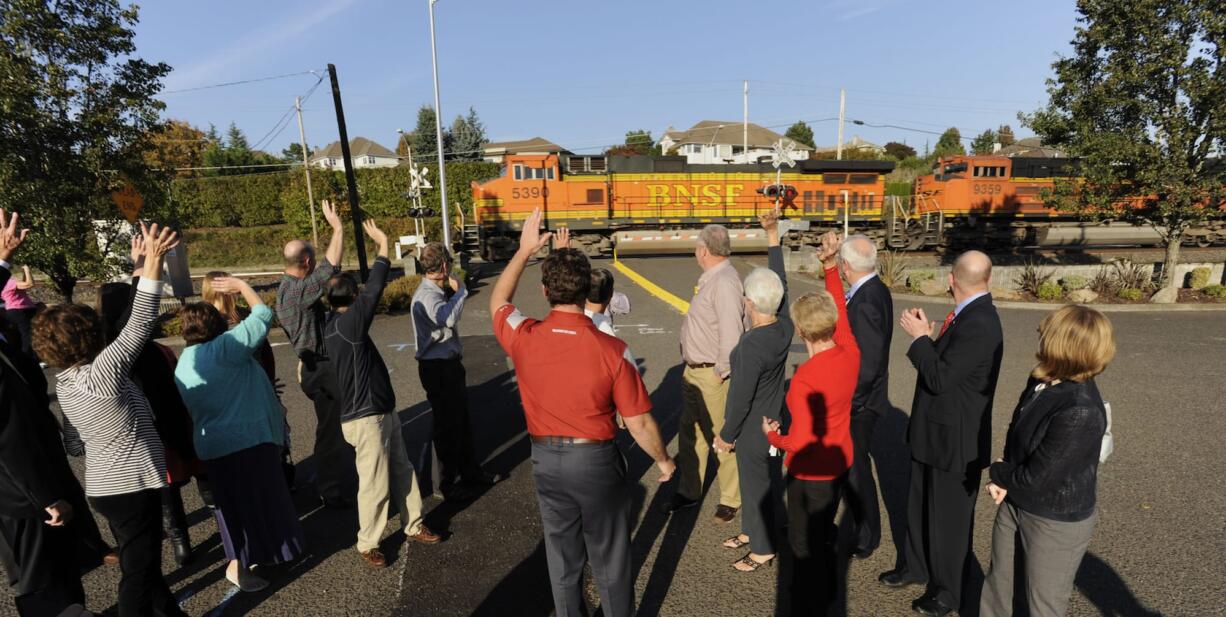 Neighbors and city staffers celebrate as a coal train passes an upgraded crossing at Southeast 147th Avenue on Wednesday, the first day quiet zones were in effect at three public crossings.