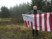 David Darby, a follower of the Sovereign Citizens movement, holds a flag on his Amboy property.