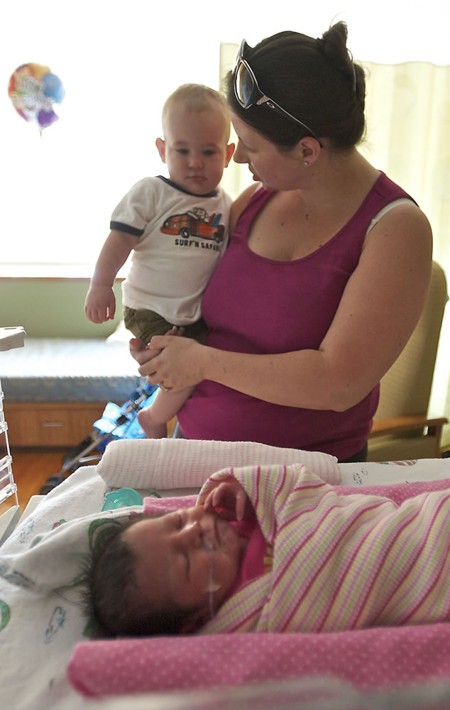 Nicole Tiffany shows her son Gavin, 13 months, his 5-day-old sister Emma inside the neonatal intensive care unit at Legacy Salmon Creek Medical Center on Saturday.