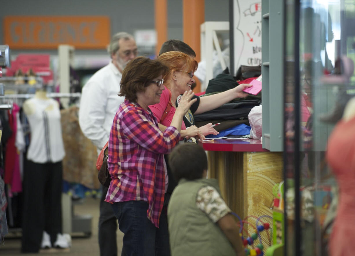 Becky Mauro of San Francisco, waves goodbye to staff at Spanky's consignment shop while accompanying friend Claudia Ross of Vancouver, who was attempting to sell clothing at the store on Wednesday. Years of economic stagnation has stretched household budgets painfully thin.