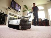 Photos by Steven Lane/The Columbian
Quam's Carpet Cleaning employee Shane Morgan cleans a carpet July 17 at the home of a family friend.