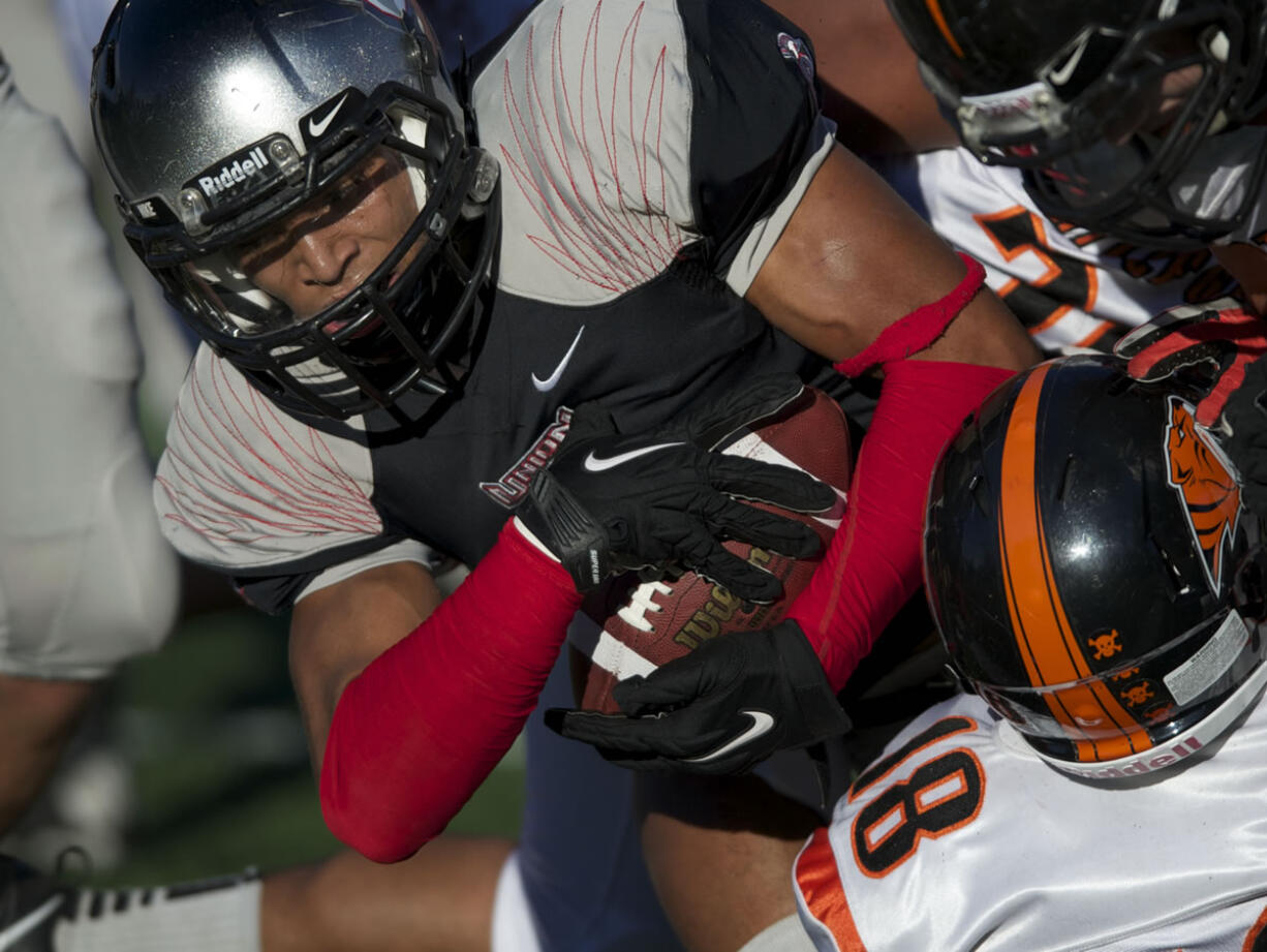 Union's Treve Ensley pushes past Battle Ground defender Josh Lemar (#18) for a touchdown in the first half at McKenzie Stadium on Friday October 5, 2012.