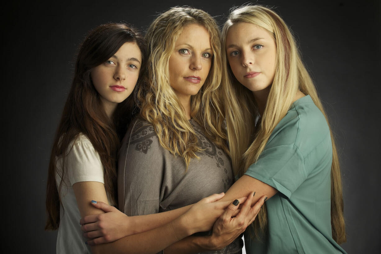 Brandy McEllrath, center, tested positive last year for a gene mutation that puts her at significant risk for breast and ovarian cancers.