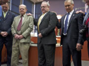 Clark County Commissioners Tom Mielke, center, and David Madore, second from right, and Clark Public Utilities Commissioner Jim Malinowski, third from left, pray after taking the oath of office with a group that includes fellow commissioner Steve Stuart, second from left, at the County Services Building.