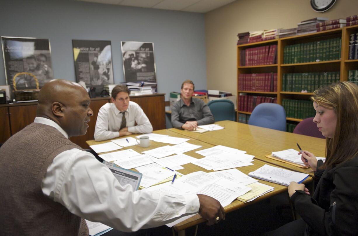 Attorneys Lou Byrd, from left, and Eric Hoffman and law student Fredrik Stig-Nielsen offer legal advice to Melissa Moore on a family law issue at the downtown Vancouver office of the Clark County Volunteer Lawyers Program.