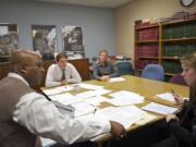 Attorneys Lou Byrd, from left, and Eric Hoffman and law student Fredrik Stig-Nielsen offer legal advice to Melissa Moore on a family law issue at the downtown Vancouver office of the Clark County Volunteer Lawyers Program.