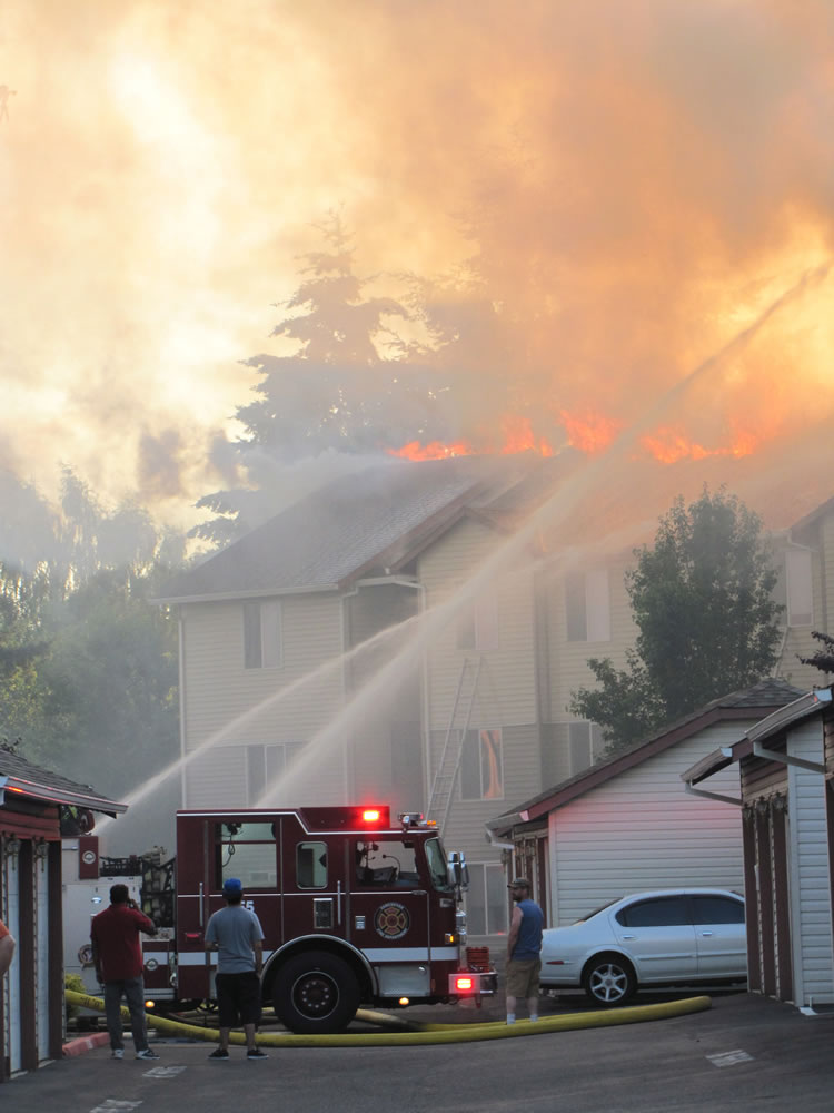 Residents of One Lake Place apartment complex look on as firefighters attack a blaze on the roof of the &quot;F&quot; building on Tuesday night.