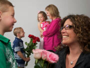 Riley Hays, 5, foreground left, gives his mother, Christa Hays, roses, as does Ryker Loukkula, 5, second from left, to his mom, Emily Loukkula, holding daughter Lucy, 3.