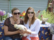 Hough: Volunteers Christina Baldisseri, left and Rachel Clark hold a silky bantam named Dodo at the Coop du Jour Backyard Chicken Coop Tour on July 14.