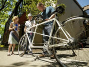 Billy Henry, right' executive director for Northwest Association for Blind Athletes, smiles as he looks over a tandem bike donated by Vancouver residents Courtney and Harly Forbes on Monday.