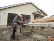 Lance Eppers, from Clearwater Construction, helps build a home March 11, 2013, in Ridgefield's Green Gables subdivision for Lennar Corp.