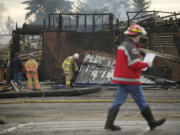 Lead investigator with the Vancouver Fire Department, John Gentry, center, looks amid the burned out rubble at Crestline Elementary School on Monday.