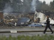 A fire investigator walks past the burned out rubble of Crestline Elementary School on Monday.