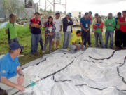 Felida: John Cordell, front, demonstrates how to set up a disaster-relief tent to a group of aid recipients in the Philippines during his December deployment with ShelterBox.