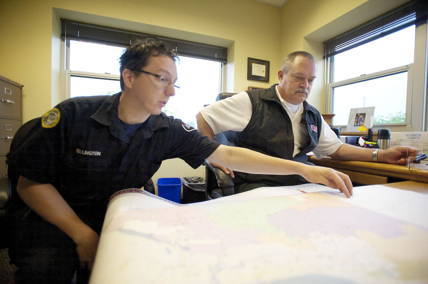 East County Fire &amp; Rescue Assistant Chief Dean Thornberry looks on as firefighter Frank Billington points out the coverage area of Station 96, which also serves as his house.